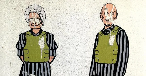 Vignetta satirica raffigurante due sopravvissuti all'Olocausto con divise da campo di concentramento e giubbotti antiproiettile, con il volto imbrattato.