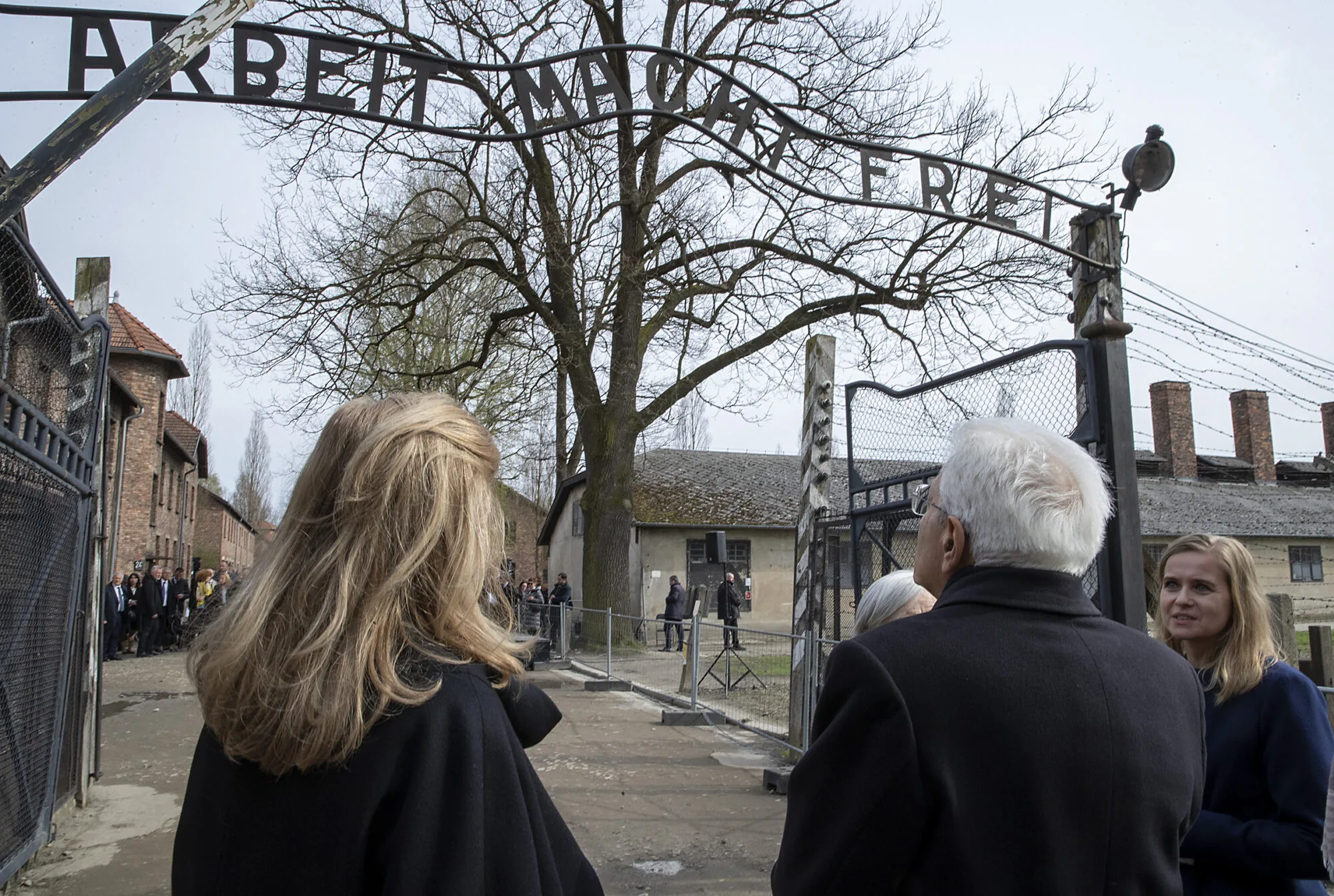 Visitatori all'ingresso del campo di concentramento di Auschwitz, sotto l'insegna "Arbeit macht frei", durante la Giornata della Memoria.
