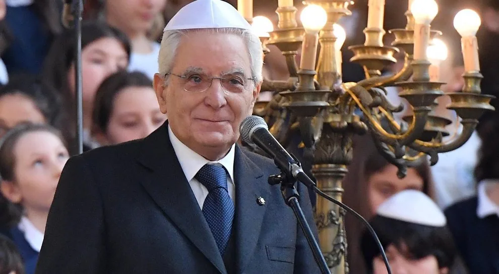 Sergio Mattarella durante una cerimonia nella comunità ebraica, con menorah e bambini sullo sfondo
