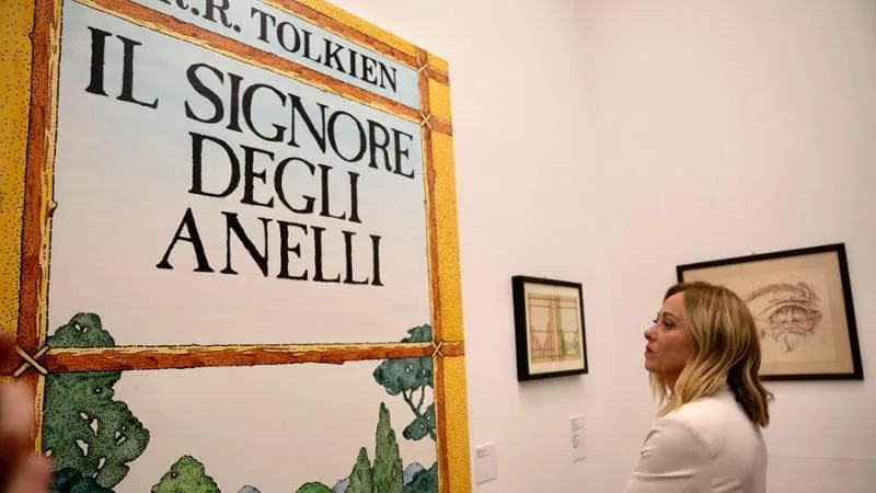 Giorgia Meloni osserva una locandina de "Il Signore degli Anelli" durante una mostra dedicata a J.R.R. Tolkien.