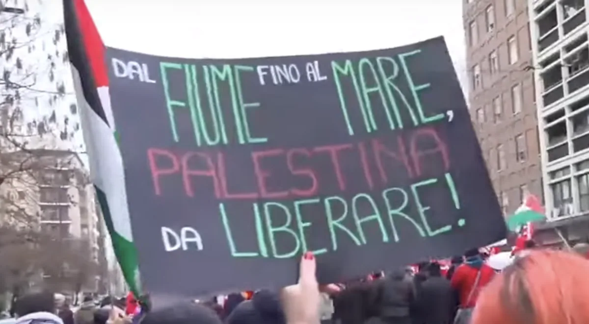 Manifestazione pro-Palestina: cartello sollevato tra la folla.