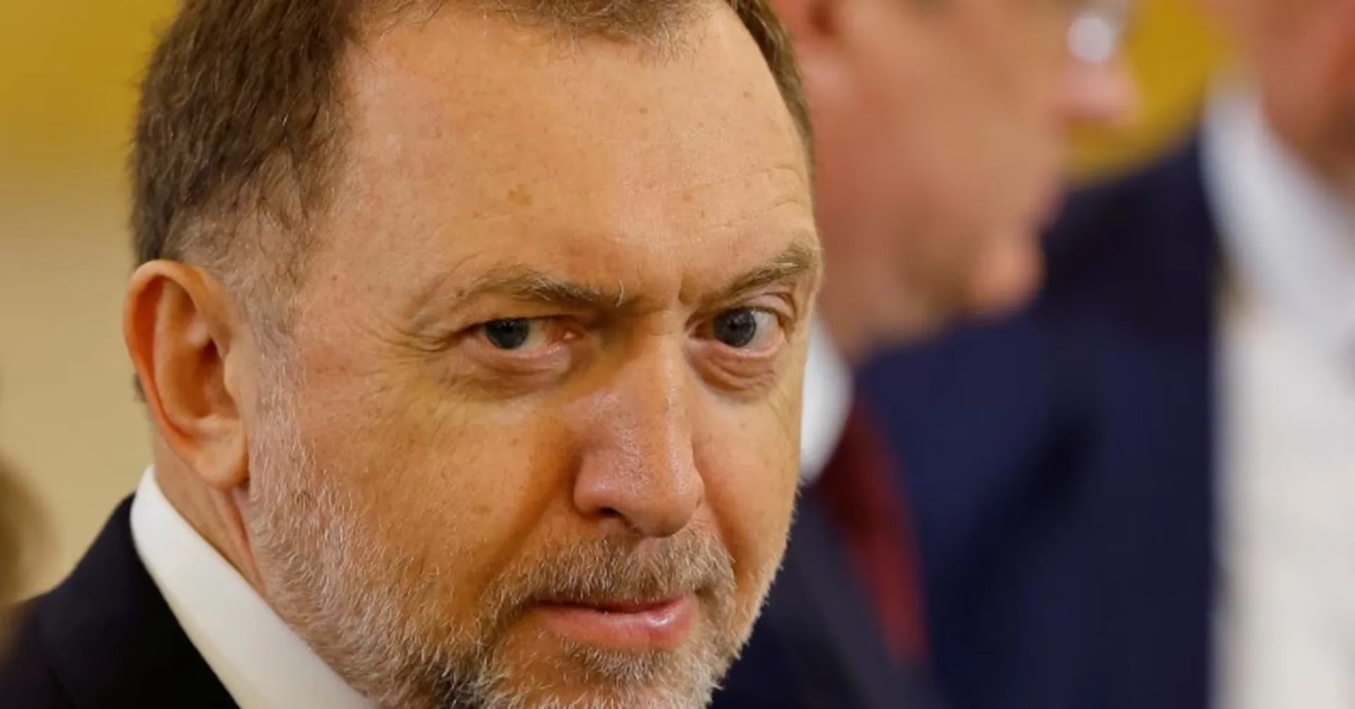 Primo piano di un oligarca russo in abito formale, coinvolto in affari internazionali legati alla NATO in Romania