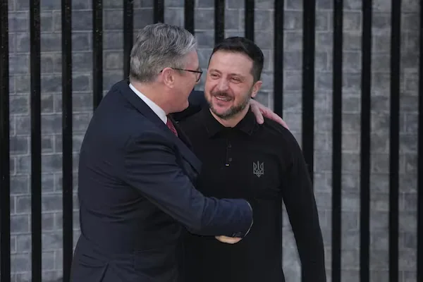 Stretta di mano tra un politico britannico e Volodymyr Zelensky, simbolo di sostegno e dialogo internazionale