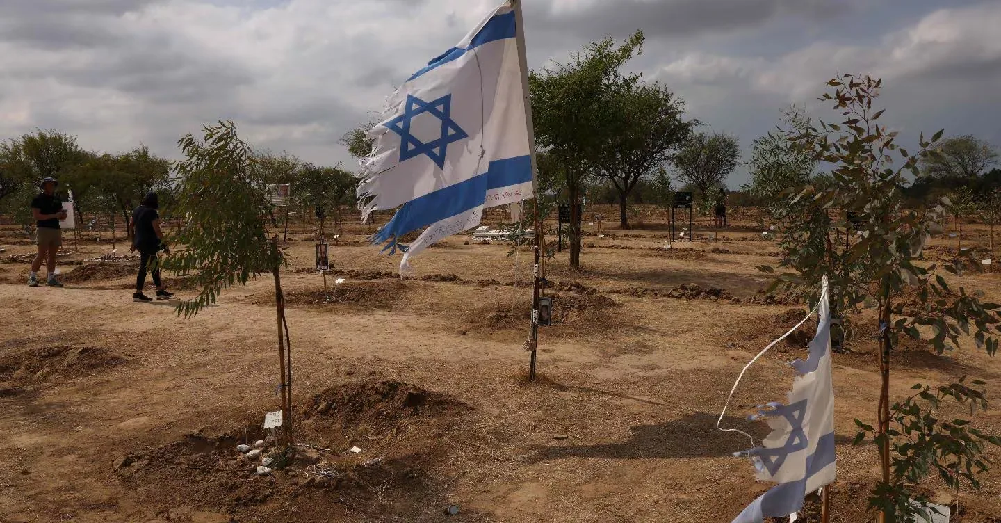 Bandiera di Israele tra tombe simboliche nel deserto dopo gli attacchi del 7 ottobre nel conflitto Israele Hamas.