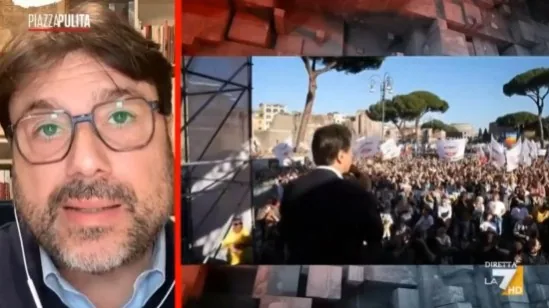 Intervento televisivo con Tomaso Montanari affiancato da un’immagine di manifestazione pubblica sulla difesa europea.